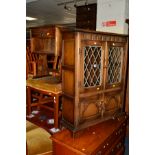 AN OAK LEAD GLAZED TWO DOOR BOOKCASE, together with two oak TV stands and an oak bedside unit(4)