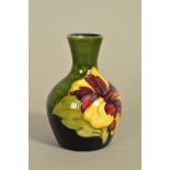 A SMALL MOORCROFT POTTERY VASE, 'Hibiscus' pattern on blue and green ground impressed marks to base,