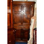 A GEORGIAN OAK PANELLED FOUR DOOR CORNER CUPBOARD, width 110cm x depth 59cm x height 205cm (key)