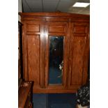 AN EDWARDIAN WALNUT TRIPLE DOOR COMPACTUM WARDROBE, with a central mirrored door, one section
