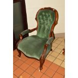 A VICTORIAN WALNUT SPOONBACK ARMCHAIR, buttoned green velour upholstery and foliate decoration