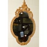 A 19TH CENTURY GILT PAINTED WALL MIRROR, with a foliate and scrolled top, 87cm x 51.5cm (sd)