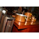 A SET OF FIVE COPPER GRADUATING PANS with hooped iron handles together with a pine handing rack (6)