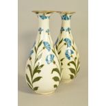 FREDERICK RHEAD FOR WOOD AND SONS, a pair of pate sur pate baluster shaped vases, decorated with