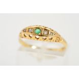 AN EARLY 20TH CENTURY 18CT GOLD EMERALD AND DIAMOND RING, the boat shaped panel set with a central