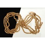 AN EARLY 20TH CENTURY 9CT GOLD GUARD CHAIN, with a lobster claw clasp and suspending a show charm,