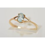 A TOPAZ RING, designed as an oval blue topaz within a four claw setting to the bifrucated