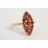 A 9CT GOLD GARNET DRESS RING, designed as a marquise shape panel set with circular garnets, with 9ct