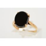 A 9CT GOLD ONYX RING, designed as an oval panel of onyx within a four claw setting, with 9ct