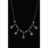 A MOONSTONE AND DIAMOND NECKLACE, designed as five tapered panels with scrolling top detail set with