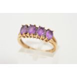 AN AMETHYST AND DIAMOND RING, designed as a row of four claw set oval amethysts each interspaced