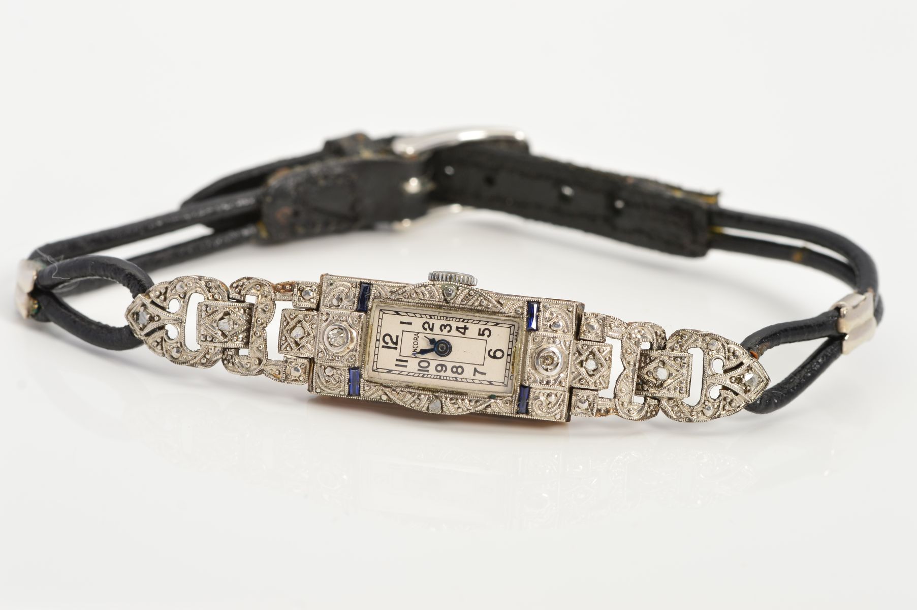 AN ART DECO 18CT GOLD DIAMOND AND SAPPHIRE COCKTAIL WATCH, the rectangular white dial with black