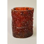 A CARVED AMBER STYLE BRUSH POT, decorated throughout with oriental decoration of monkeys in trees,