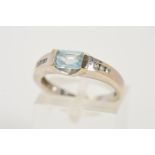 A 9CT WHITE GOLD GEM RING, designed as a central rectangular shape blue topaz, the shoulders each