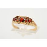 A 9CT GOLD GARNET RING, designed as three circular garnets interspaced by smaller circular