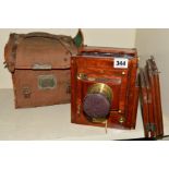 A MARION & CO MAHOGANY AND BRASS PLATE CAMERA, fitted with an unnamed lens and comes with a soft