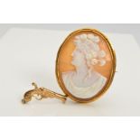 A CAMEO BROOCH AND A 9CT GOLD GUN CHARM, the cameo brooch of oval outline carved to depict a lady in