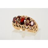 A 1970'S 9CT GOLD GARNET RING, designed as three graduated oval garnets within claw settings