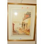 A WATERCOLOUR OF A COTTAGE OVERLOOKING A HARBOUR, indistinctly signed, dated 1921, mounted, framed