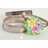 THREE BANGLES AND A BROOCH, to include two hinged silver bangles with floral and foliate decoration,