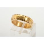 A BAND RING, designed with engraved floral detail (detail worn), stamped 22ct, ring size O 1/2,