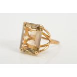 A 9CT GOLD SMOKY QUARTZ RING, designed as a rectangular smoky quartz in a four claw setting to the