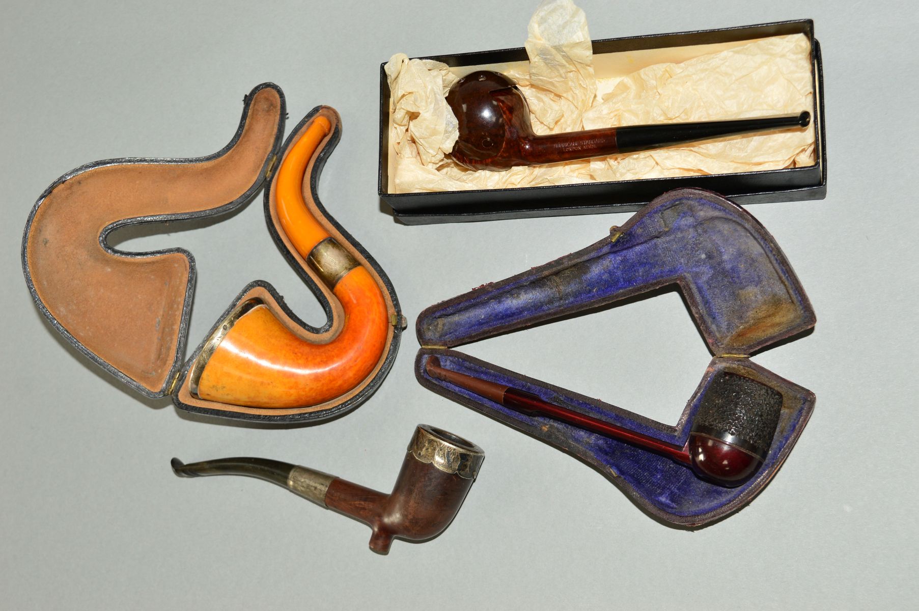 FOUR VARIOUS PIPES, to include cased silver rimmed, a loose silver mounted pipe, a boxed Hurricane