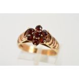 A 9CT GOLD GARNET CLUSTER RING, designed as a floral cluster of circular claw set garnets to the