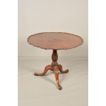A GEORGE III MAHOGANY TRIPOD TABLE WITH CIRCULAR PIE CRUST TILT TOP, on a baluster pedestal carved