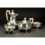 A GEORGE V SILVER FOUR PIECE TEASET, of circular form, with wavy rims, teapot and hot water jug with