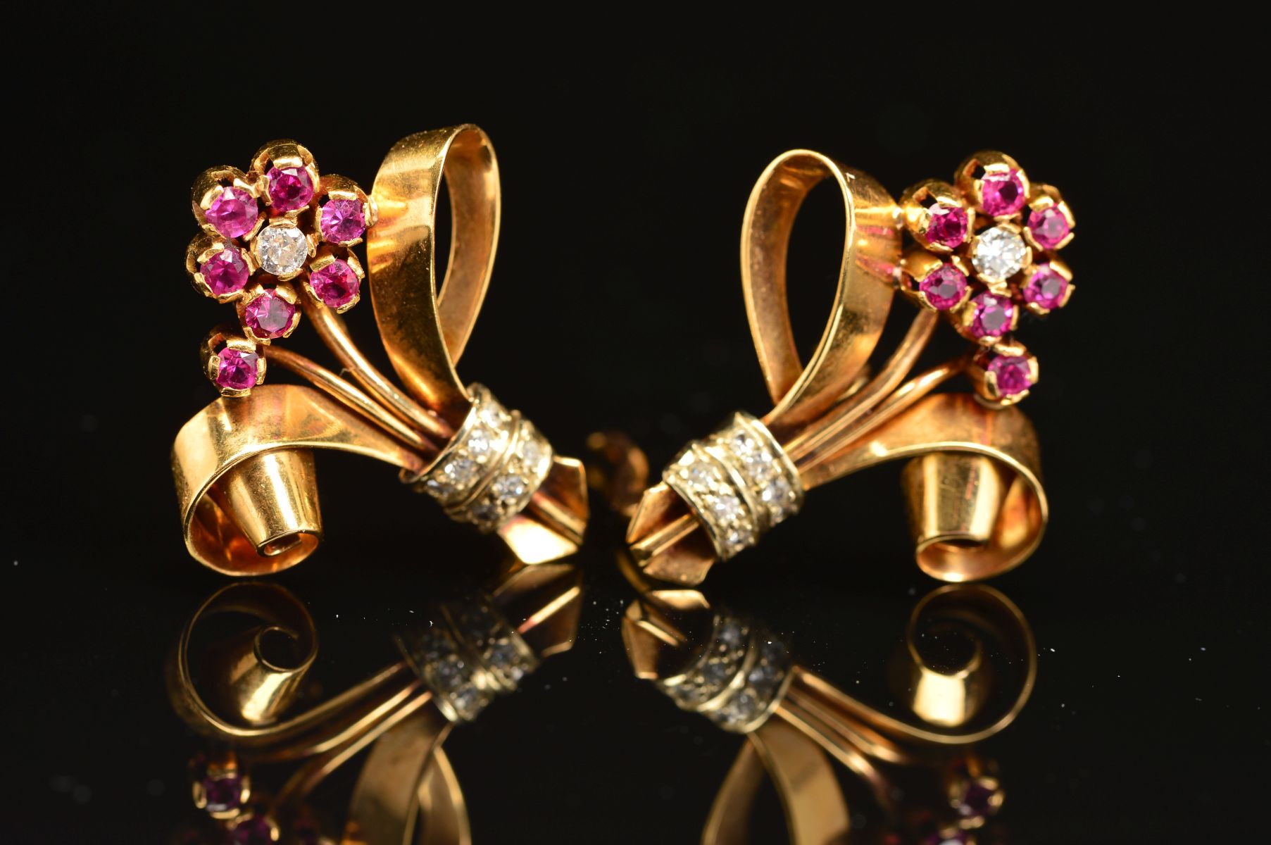 A MID 20TH CENTURY PAIR OF RUBY AND DIAMOND EARRINGS, floral design with scroll detail, measuring