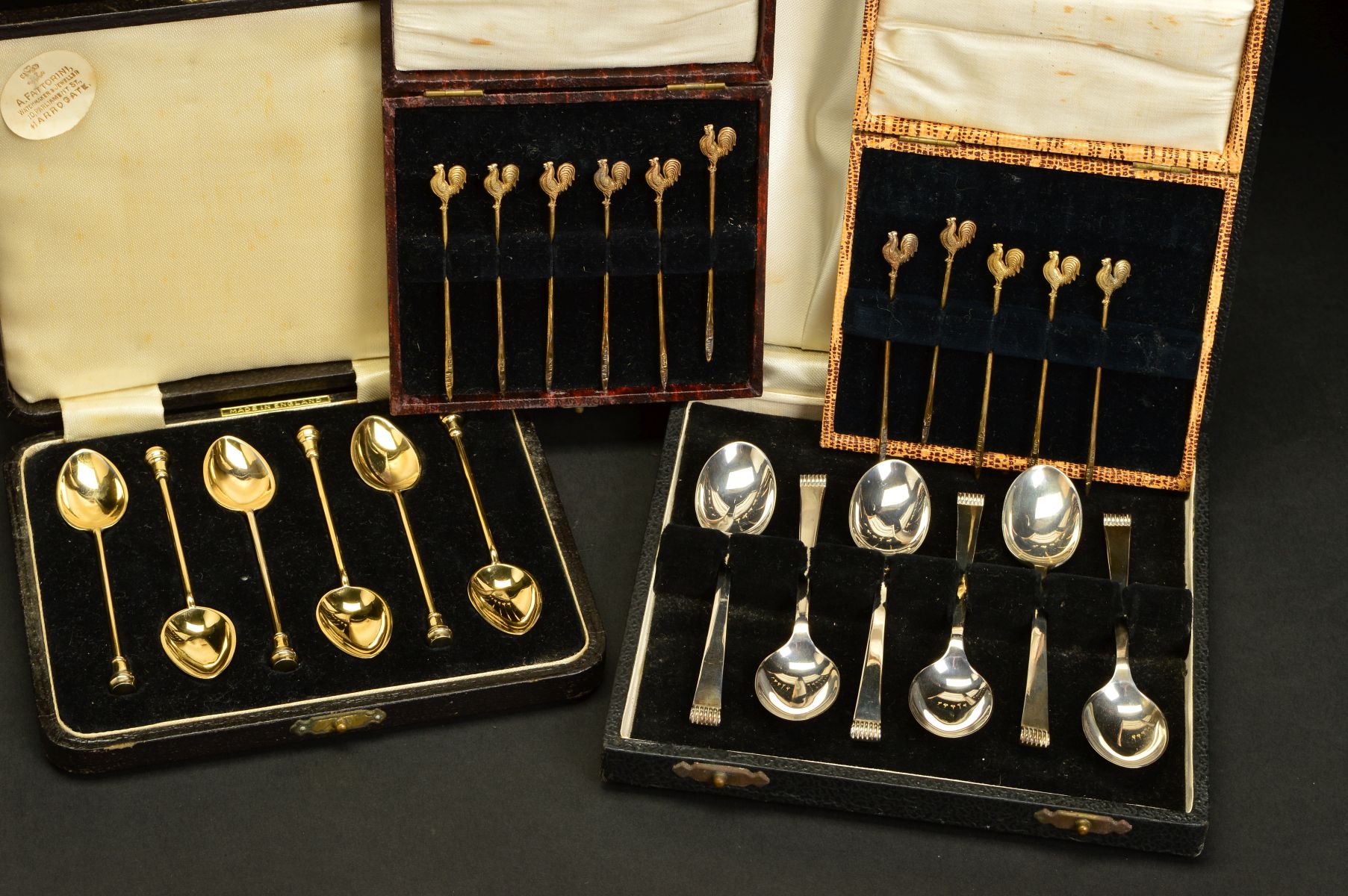 A CASED SET OF SIX ELIZABETH II SILVER GILT AND HARLEQUIN ENAMEL COFFEE SPOONS, circular seal end