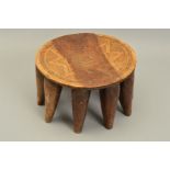 A 19TH CENTURY AFRICAN TRIBAL CARVED HARDWOOD STOOL, the circular seat carved with geometric