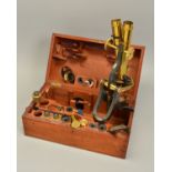 A LACQUERED BRASS BINOCULAR MICROSCOPE BY HENRY CROUCH OF LONDON NO.1188, in a fitted walnut case