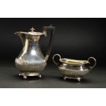 A GEORGE V SILVER HOT WATER JUG AND MATCHING TWIN HANDLED SUGAR BOWL, shaped rectangular rims with