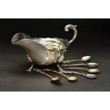 AN EARLY 20TH CENTURY SILVER SAUCE BOAT, of oval form, wavy rim, 'S' scroll handle, on three shell