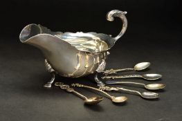 AN EARLY 20TH CENTURY SILVER SAUCE BOAT, of oval form, wavy rim, 'S' scroll handle, on three shell