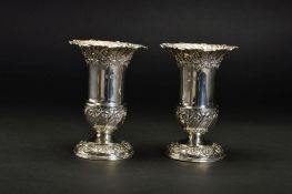 A PAIR OF LATE VICTORIAN SILVER VASES, of urn form, crimped rims above repousse wrythen and