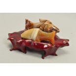 TWO CARVED FISH ORNAMENTS ON WOODEN BASE, in jasper and banded agate, measuring approximately 7cm,