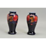 A NEAR PAIR OF WILLIAM MOORCROFT POMEGRANTE DESIGN BALUSTER VASES, mottled dark ground, impressed '