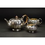 A LATE VICTORIAN SILVER THREE PIECE TEASET, of lobed circular form with engraved cartouches and
