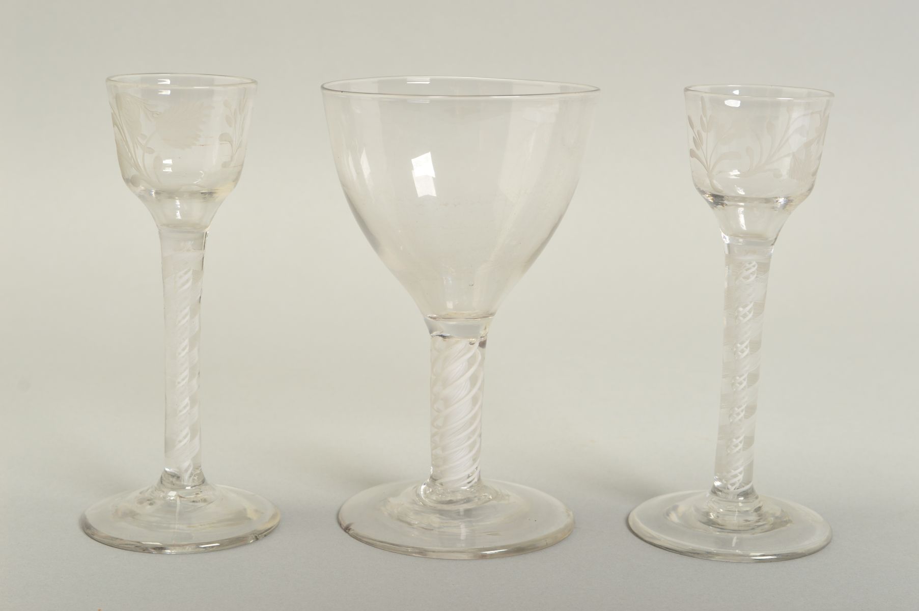 A PAIR OF 18TH CENTURY CORDIAL GLASSES, the ogee bowls engraved with flower head, leaves and a