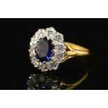 A MODERN 18CT DIAMOND AND SAPPHIRE OVAL CLUSTER RING, centring on an oval blue sapphire measuring