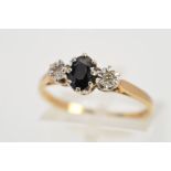 A 9CT GOLD SAPPHIRE AND DIAMOND RING, designed as a central oval sapphire flanked by single cut