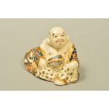 AN EARLY 20TH CENTURY JAPANESE SATSUMA POTTERY SEATED FIGURE OF A MAN OR BUDDAH WITH FAN, painted