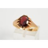 A 9CT GARNET GOLD RING, set with a central oval garnet within a claw setting, with 9ct hallmark