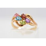 A 9CT GOLD MULTI-GEM RING, of a cross over style design centrally claw set with pear shape and