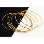 SEVEN SMALL SLAVE BANGLES, of plain D-shape design, five with 9ct hallmarks, approximate inner