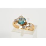 A 9CT GOLD GEM RING, of cross over design set diagonally with a central oval blue gem assessed as