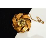 A CITRINE BROOCH, designed as a central circular citrine within an interlocking surround, with